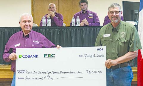 Round Top Schuetzen Verein Preservatio n Inc. received $5,000 for renovation projects at its historic hall. Shown are (foreground, from left) FEC board president Joseph Kruppa; and Michael Sacks, vice president of community affairs for Round Top Schuetzen Verein Preservation Inc.