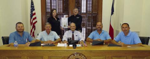 On hand for the proclamation commemorating FEC’s 85th anniversary were: (front, from left) Precinct 4 Commissioner Drew Brossmann, Precinct 3 Commissioner Harvey Berckenhoff, County Judge Joe Weber, Precinct 2 Commissioner Luke Sternadel, Precinct 1 Commissioner Jason McBroom; (back, from left) FEC Marketing and Training Coordinator Tracy Denton, and FEC General Manager Gary Don Nietsche. Photo By Melanie Berger / Courtesy of Flatonia Argus