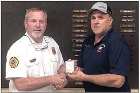 Jeff Proske (left) presents Darren Guentert with his chief’s badge at last week’s SVFD meeting.