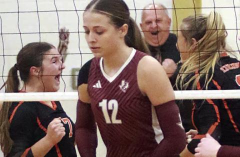 Behind a dejected Johnson City player, Landry Zapalac (left) celebrates with Reagan Dusek (right) after their block closed out the match while head coach Donald Zapalac shows his jubilation in the background. Sticker Photo By Darrell Vyvjala