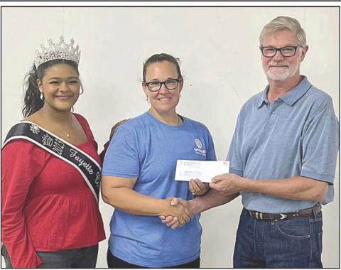 LA GRANGE OPTIMIST CLUB received a donation of $2,964.50. Shown are (from left) Queen Harper Henneke, Optimist Club representative Misty Nox and Fair president Mike Zuhn.