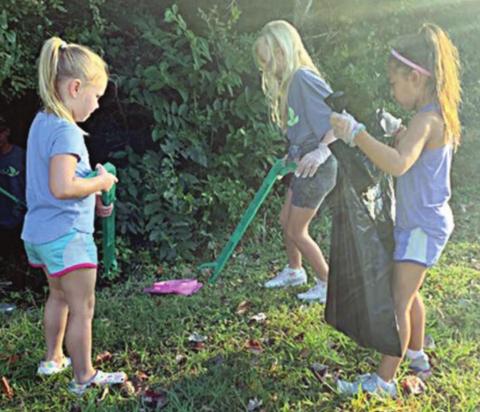 Chandler Bubela (front, left), Ella Banse (front, right), and Brynn Bubela help pick up trash as part of Keep Schulenburg Beautiful’s Fall Sweep.