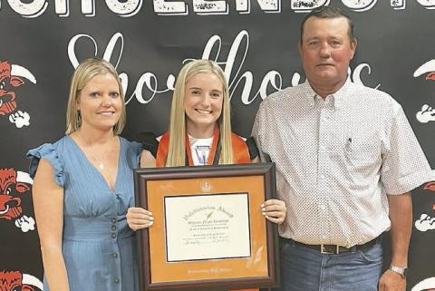 Madison Kunschick (center) received the valedictorian plaque with her parents, Michelle and David Kunschick alongside her, at the Senior Scholarship Banquet last week. Sticker Photo By Darrell Vyvjala