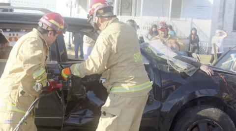 Firefighters use extrication tools to remove the door of the vehicle from which Katry Kobza was ejected through the windshield and later pronounced “deceased.” Sticker Photo By Darrell Vyvjala
