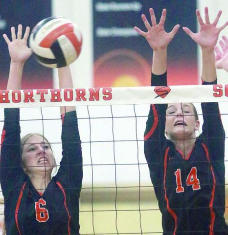 Clara Magliolo (left) and Emmrie Marx go up for a block against the Lady Bulldogs. Sticker Photo By Darrell Vyvjala