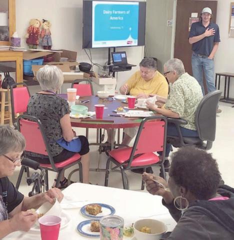 SPEAKER – Kevin Raabe (standing at back right), plant manager at Dairy Farmers of America, gave a presentation at NVCC. Members seated at the table in the foreground are Jo Nell Vacek on the left and Freda Ellison on the right.