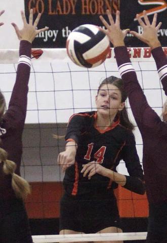 Emmrie Marx fires down one of her 17 kills Friday in between two blockers. Sticker Photo By Darrell Vyvjala