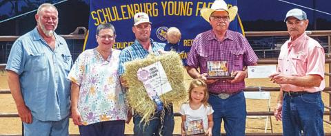 Reserve champion - Kutac Farms with an entry of coastal bermudagrass hay. The bale sold for $900 and buyers were Moeller Custom Lawn Mowing & Shredding, Bubela Tree Service & Arbor Care and Weimar Vet Clinic. La Grange Farm & Ranch donated 1,000 lbs. of fertilizer to the winner. Shown are (from left) Ed and Jennifer Moeller of Moeller Custom Lawn Service; Aaron Kutac, Allen Kutac, Ainsley Kutac and A.J. Kutac of Kutac Farms; and Mark Vecera of the Young Farmers. Photo By Andy Behlen/Fayette Co. Record