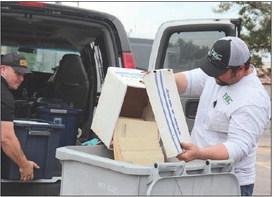 At last year’s document Shred Day, Fayette Electric Cooperative lineman Justin Whited assists an employee of Gruene Shredding.