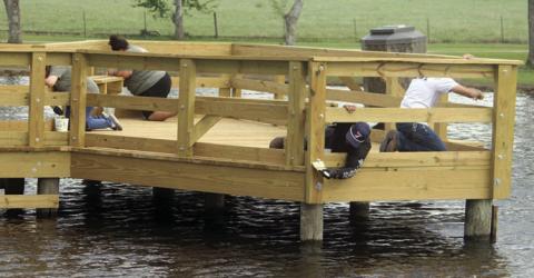 Sour LCRA employees apply sealant to the City’s newly-constructed pier at the Sports Complex last Friday morning. Sticker Photo By Darrell Vyvjala