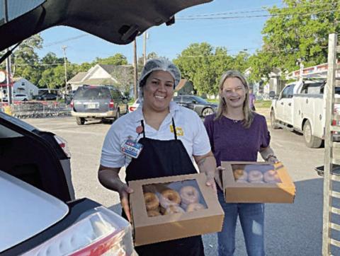 Loading up donuts for National Donut Day distribution to Fayette County first responders are Claudia Reyes (left), La Grange H-E-B bakery manager, and Krystal Seger (right), Fayette County Salvation Army Chapter board member.