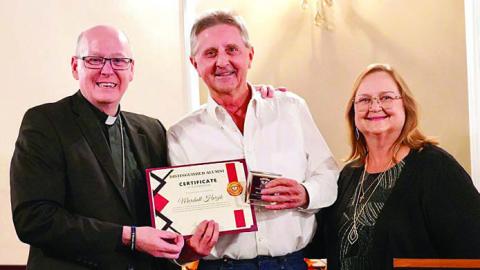 Marshall Herzik (center) was presented the Distinguished Alumni Award at an event in Victoria on Oct. 16 as the recipient from St. Rose of Lima Catholic School. He is shown with Diocese of Victoria Bishop Brendan Cahill (left) and St. Rose principal Rosanne Gallia (right).