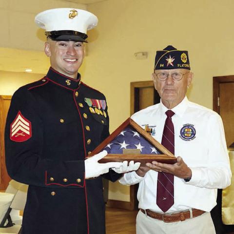 Flatonia American Legion Post 94 Commander Danny Vyvjala (right) presents a folded flag to the youngest veteran in attendance, 29-year-old Montana Olle of Schulenburg (left). Photo By Melanie Berger / Courtesy of Flatonia Argus