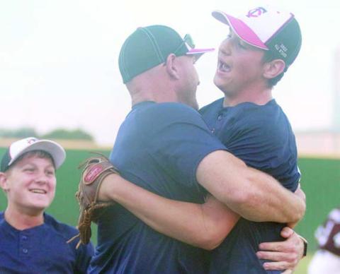 Brayson Prihoda (right) get a hug from coach Josh Morgan following the final out Wednesday with Josh’s son, Nolan (left) coming to join the celebration. Sticker Photo By Darrell Vyvjala