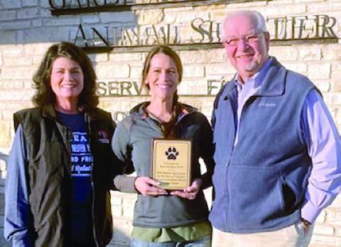 A plaque is presented to Dr. Rylee Hatfield (center), board president of the Gardenia E. Janssen Animal Shelter since 2019, by Teresa Brown (left), GJAS executive director, and Frank Reichert (right), GJAS poard president elect.