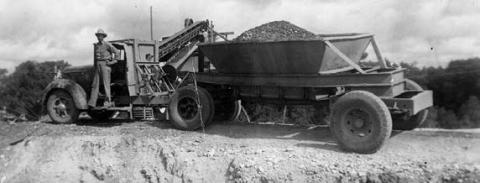 Photograph of an unidentified man standing on the running board of a gravel truck. Courtesy of Fayette Heritage Museum &amp; Archives