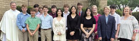 Shown at the Chrism Mass in Victor ia are (from left) St. Rose pastor Rev. Jasper Liggio, Caden Herzik, Brayden Stoever, Brant Redman, Wyatt Matura, Dillon Goedrich, Ian Reeves, Lilly Wotipka, Mason Kunschick, Morgan Steinhauser, Connor Lichnovsky, Joseline Campos, Ava Bubela, Joseph Schindler, Denim Sommer and St. Rose principal Rosanne Gallia.