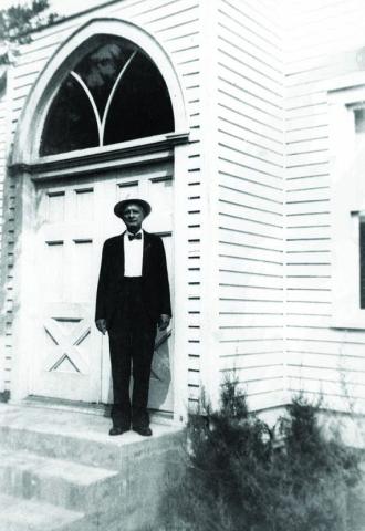 Charles Peter Luck in his later years, standing on the front steps of the Trinity Lutheran Church at Black Jack Springs. Courtesy of Fayette Heritage Museum &amp; Archives