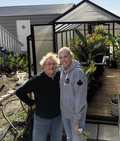 Helping Hero April Pearson (right) assists Ginny Berwick in securing her plants inside the greenhouse before cooler weather sets in. Any member of Senior Connections who needs help with small household tasks can contact the Center at 743-3227.