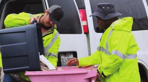 FAYETTE ELECTRIC COOPERATIVE groundman Justin Neiser dumps FEC member documents into a container for ProShred’s Terry McCoy to place in the shredding truck.