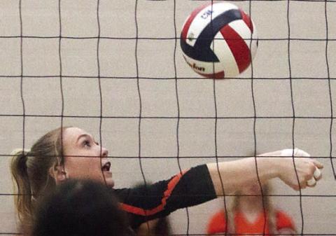 Reagan Dusek saves a ball near the net in the second set. Sticker Photo By Darrell Vyvjala