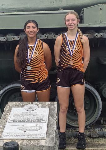 Ruby Rodriguez (left) and Michaela Kollmann show off the medals they earned in Navasota at the memorial in August Horst Park.