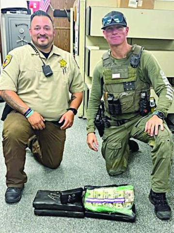 Deputy Herman Olvera (left) and Drug Interdiction Investigator David Smith (right) are pictured with the $191,000 in U.S. currency seized after a traffic stop on Interstate 10.