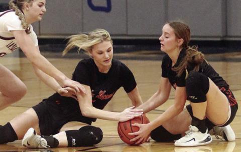 Alana Herzik (left) and Miranda Bonner combine for a take-away in the first quarter. Sticker Photo By Darrell Vyvjala