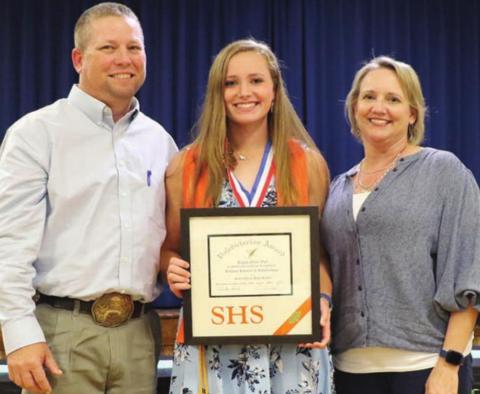 Regan Lux (center) accepts the valedictorian plaque at the academic banquet with her parents, Brad and Terah alongside. Photo By Audrey Kristynik