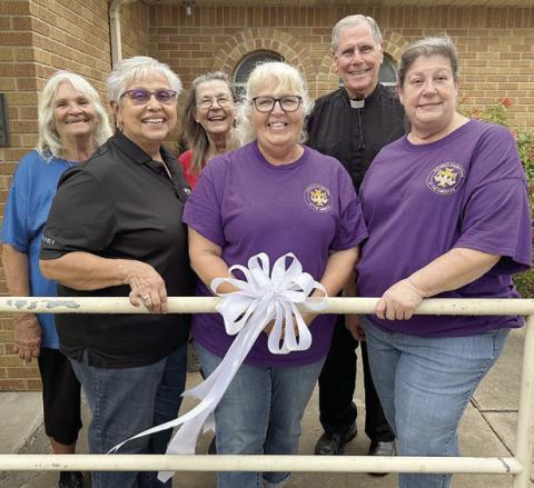 Shown with a white ribbon in front of the St. Rose Parish office are (front row, from left) Rosa Galipp, CDA district deputy; Phyllis Valchar, Court St. Rose recording secretary; Grace Lebeda, Court St. Rose regent; (back row) Clara Clark and Barbara Veselka, representing Court St. Rose; and Rev. Jasper Liggio, St. Rose pastor.