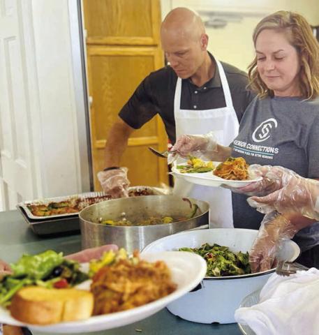 Serving a delicious ho me-coo ked meal of lasagna, fresh squash from a member’s garden and salad at the membership drive in Flatonia were (from left) board member Chip Bubela and volunteer Kandice Dalmolin.