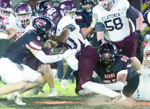 Jayvan Luhrs (No. 55) and Emerson Harvey (left) tackle Adrian Anderson for a loss of 1 in the third quarter. Sticker Photo By Brandt Vyvjala