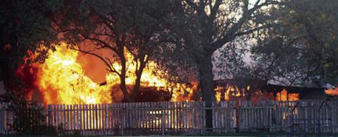 Flames totally engulf the outbuilding at 507 Bucek St. Sticker Photo By Darrell Vyvjala