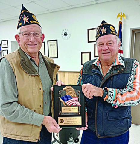 Post Commander Bob Heinrich (right) presents the Legionnaire of the Year award to Harvey Oeding.