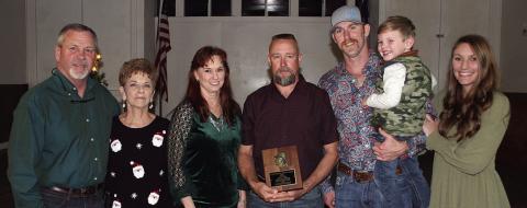 OUTSTANDING SERVICE – Second Assistant Chief Randy Wick (center) receives the Outstanding Service Award for 2022 for making the highest percentage of calls, meetings, and drills at 89 percent. The award is sponsored each year by the family of the late Chief Roland Proske. Making the presentation were (from left) Jeff, Pat, and Terry Proske along with Doran Proske (third from right), Kelsey Svetlik (right), and Kelsey’s son, Will. Sticker Photo By Darrell Vyvjala