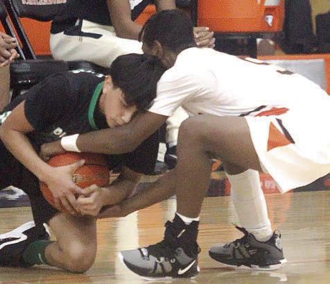 DeMarion Glass ties up a Bobcat in the second half to get the ball back for the Horns. Sticker Photo By Darrell Vyvjala
