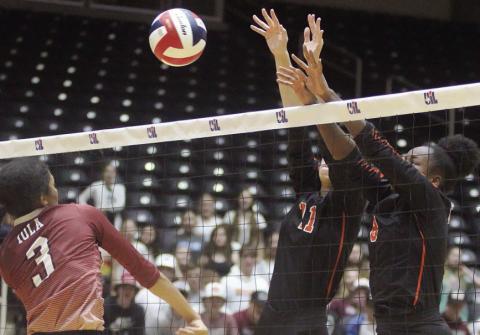 Meredith Magliolo (No. 11) and Jessalyn Gipson team up for a block in the third set. Sticker Photo By Darrell Vyvjala