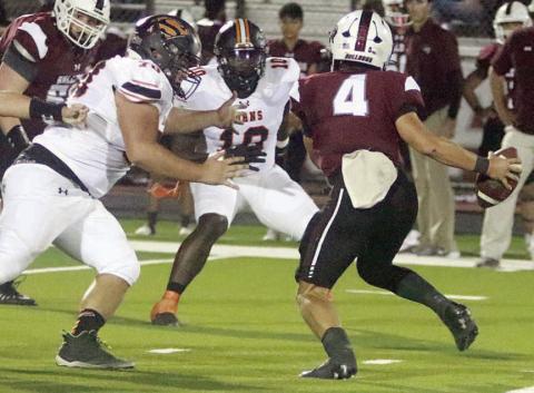 Marshall Wellborn (left) and Tavondrick Ellison close in on Bulldog quarterback Beck Zimmerman for a stop in the first quarter. Sticker Photo By Darrell Vyvjala
