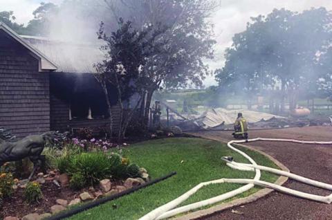 Multiple lines remain handy and smoke drifts from the home in the Freyburg area after firefighters extinguished the blaze on June 1. The carport (at right) burned to the ground and one adjoining section was a total loss but about half of the structure was saved. Photo Courtesy of Schulenburg VFD