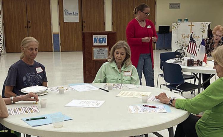 Retired teach ers “studying” bingo cards at the conclusion of the May meeting.