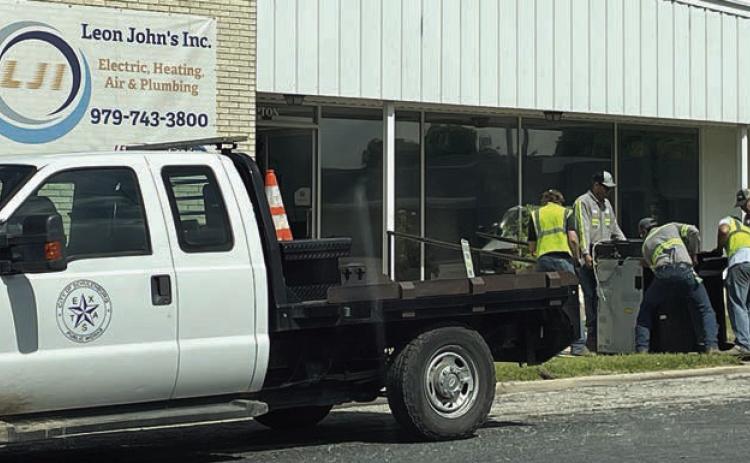 As part of the move from 535 North Main St. to the temporary City Hall location at 605 Upton Ave. (Leon John’s, Inc.), City workers unload a copy machine on Friday. Sticker Photo By Darrell Vyvjala