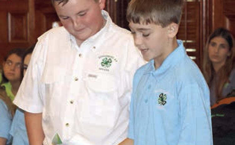 Abraham McBride (left) and Crockett Guenther of the Schulenburg 4-H Club present their report to the Fayette County Commissioners Court. Photo By Melanie Berger / Courtesy of Flatonia Argus