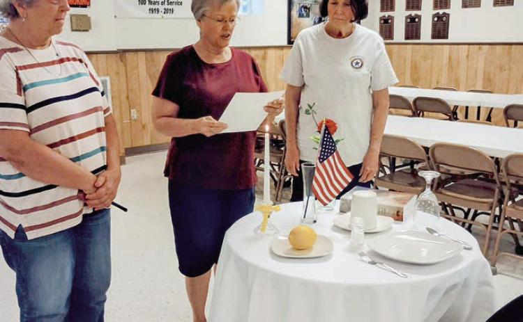 The table and its contents hold special significance for the solemn POW/MIA ceremony. The table, set for one, includes a white tablecloth, red rose, yellow ribbon, slice of lemon, salt, inverted glass, empty chair and candle. Legion Auxiliary members conducting the ceremony included (from left) Debbie Behlen, Patricia Hranicky and Patricia Marty.