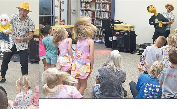 Puppeteer Mr. Leo and his cool goat (left) interact with youngsters after the children enjoyed a song and dance with him and his buddy, “Tommy” (above). The show last Friday morning was the first of the local public library’s Summer Reading Program that continues through late July. Sticker Photos By Darrell Vyvjala