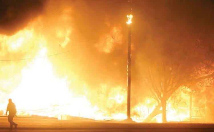 Fire fully engulfs the two homes to the east of Schulenburg Liquor Store near the intersection of Highway 90 and Highway 77. Sticker Photo By Darrell Vyvjala
