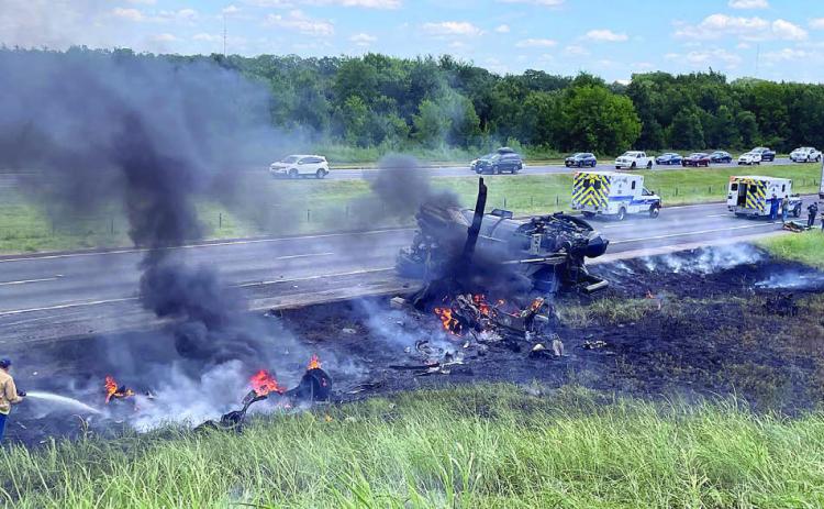 A Schulenburg VFD firefighter (bottom, left) works to extinguish the remaining flames while Fayette County EMS personnel (top, right) work to try to save the victim of an accident on Interstate 10 this past Saturday.