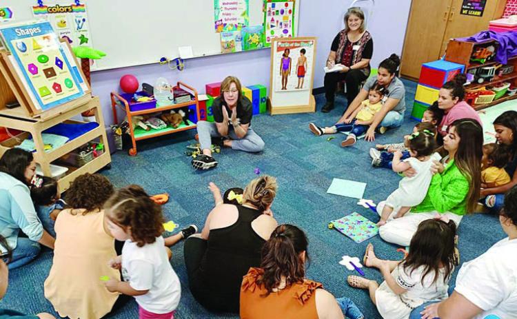 Juanita Duchicela (seated at back center) leads a session in the Learn &amp; Play Room. Duchicela is retiring from the Parents As Teachers program after 20 years of service.