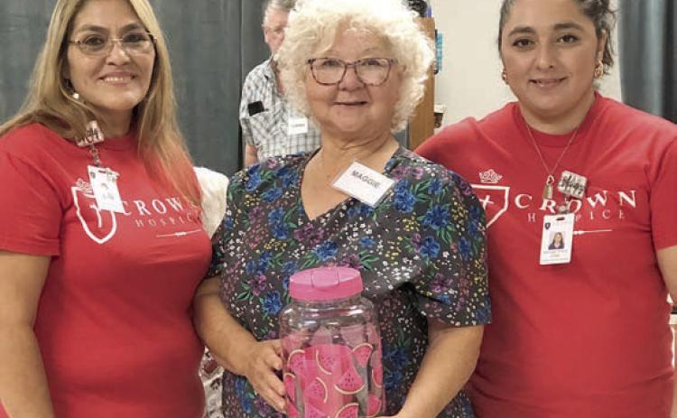 Bingo callers from Crown Hospice of Victoria – Addy Priour (left) and Mary Rubio (right) – are shown with blackout winner Margaret Lozarro (center).