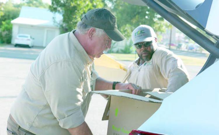 Un loading documents for shredding at last year’s Community Shred Day are FEC’s Larry Sulak and Macy Scott.