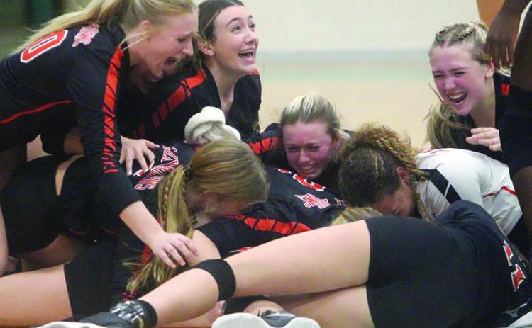 Lady Horn players go to the floor in jubilation following the final point of the regional championship match on Saturday afternoon at Brenham High School. Sticker Photo By Darrell Vyvjala
